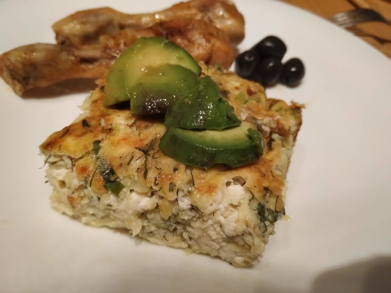 Greek style courgettes casserole with a few slices of avocado, olives and baked chicken drumsticks