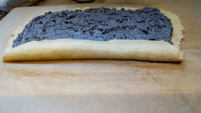 Spread half the poppy seed filling leaving a 1-inch border and roll Poppy Seed Roll