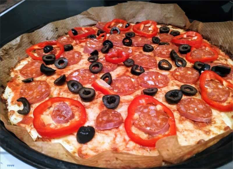 Add sliced black olives, slices of chorizo and a few slices of red pepper Cauliflower Base Pizza