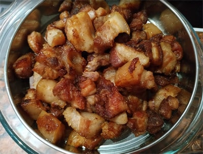 With a skimmer take out the pork cracklings and place them into a colander Homemade Pork Cracklings