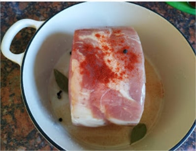 Place the joint in an iron cast pan and then add the water with 3-4 bay leaves, peppercorns and the smoked paprika powder Large Gammon Joint
