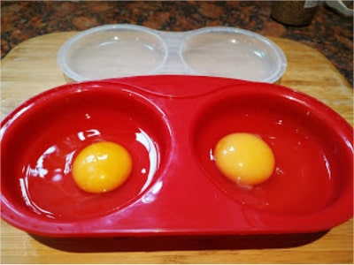 Crack one egg into each cup of egg poacher base Microwave Poached Eggs