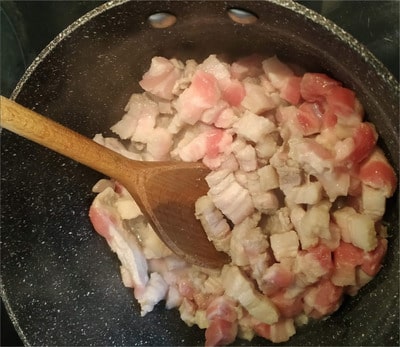 Place a saucepan on medium heat (knob on 4) and add the belly cuts with 1/3 cup of water and flaky sea salt on top Pork Belly Bites
