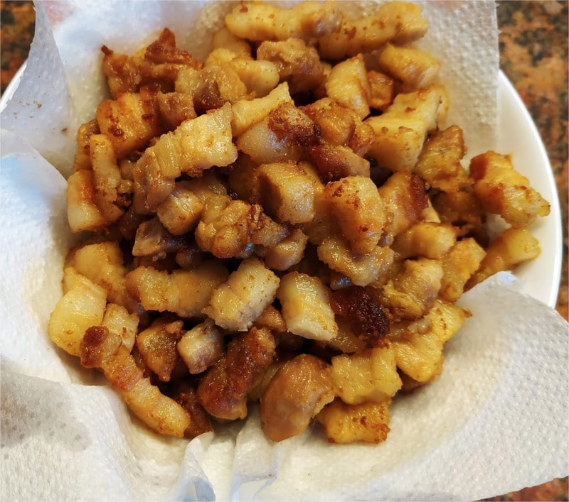 With a skimmer take out the pork belly bites and place them in a medium size bowl, which has been lined with a paper towel. This will absorb the excess of fat Pork Belly Bites